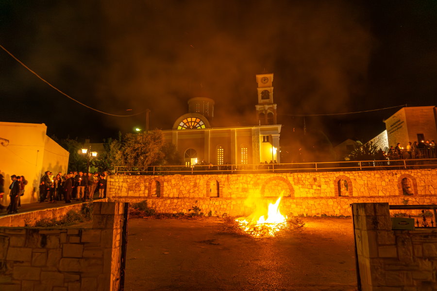 Пасха на Крите в деревне Агия Марина у церкви Агиос Спиридонас. Верующие несут домой Благодатный огонь, а в центре фото догорает костёр, на котором сожгли чучело Иуды.