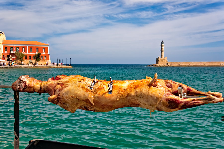 Венецианская гавань в Старом порту Ханьи с видом на египетский маяк. На переднем плане жареный на вертеле барашек в Пасхальное Воскресенье на Крите.