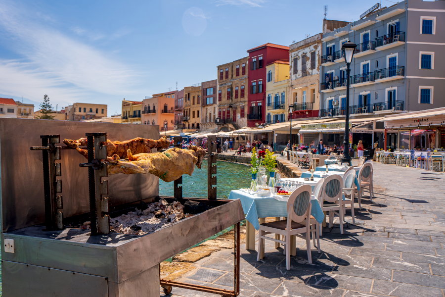 Пасхальное Воскресенье на Крите в Венецианском порту города Ханья. Столы и стулья вынесли из ближайших таверн и поставили ближе к воде. В мангалах готовится традиционное пасхальное угощение  - жареный на углях барашек.